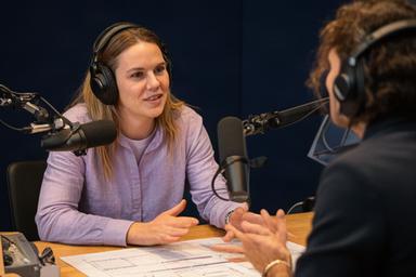 Gunalp Ataoglu bespreekt een podcastplanning aan een studiodesk in Uitgeest