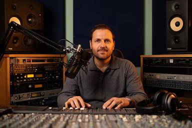 Moh Dzhurova achter een audiomengtafel in de podcaststudio van Uitgeest